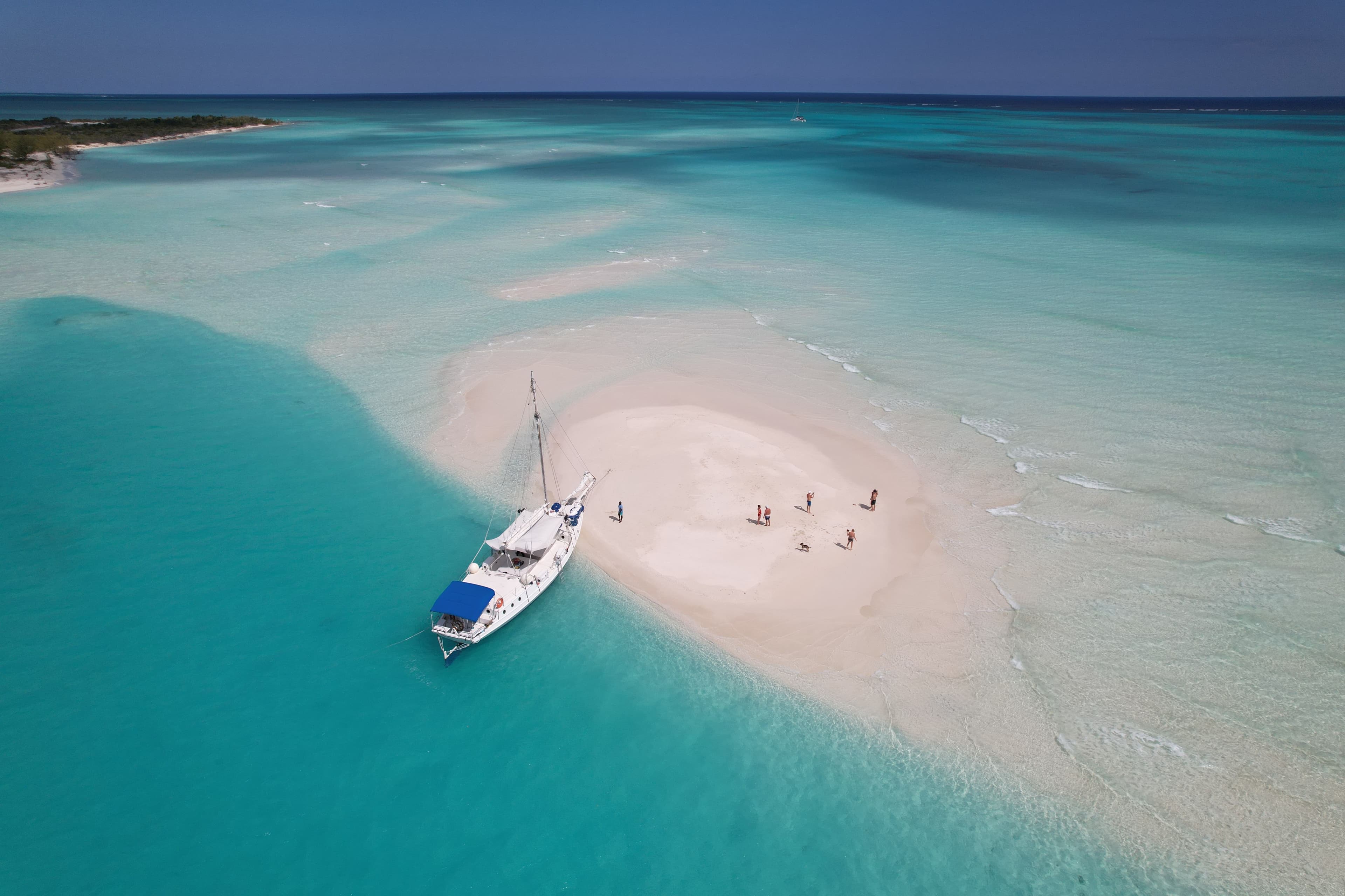 Private 70ft sailboat anchored at a white sandbar, Turks and Caicos aerial