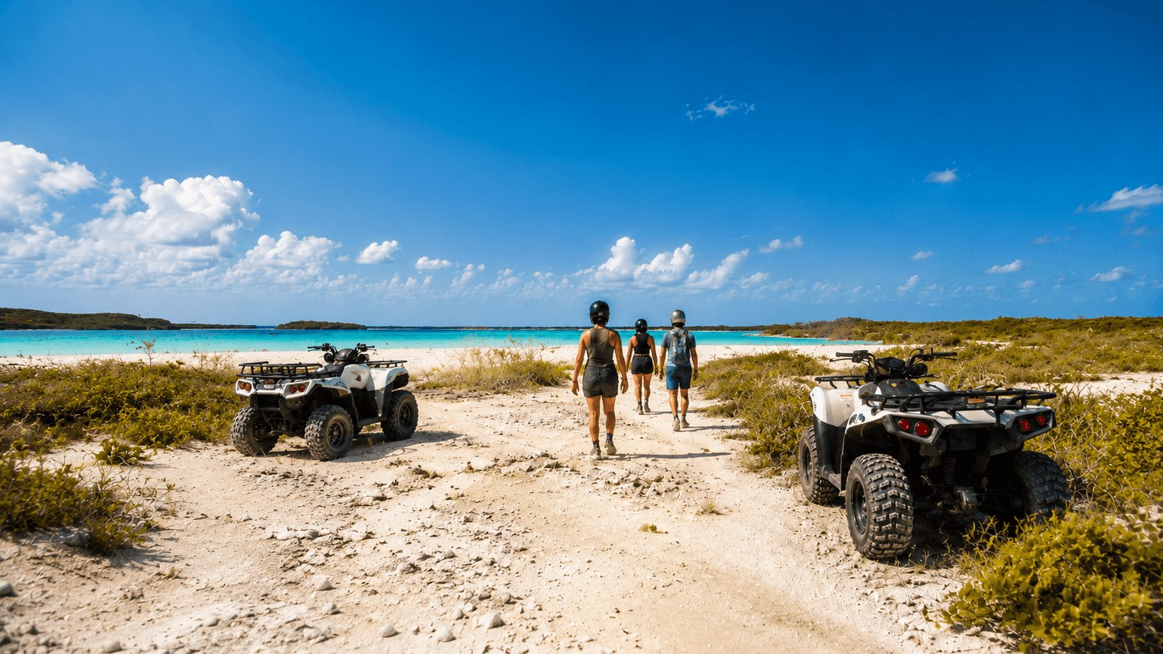 Guests walking their ATVs toward a turquoise lagoon beach